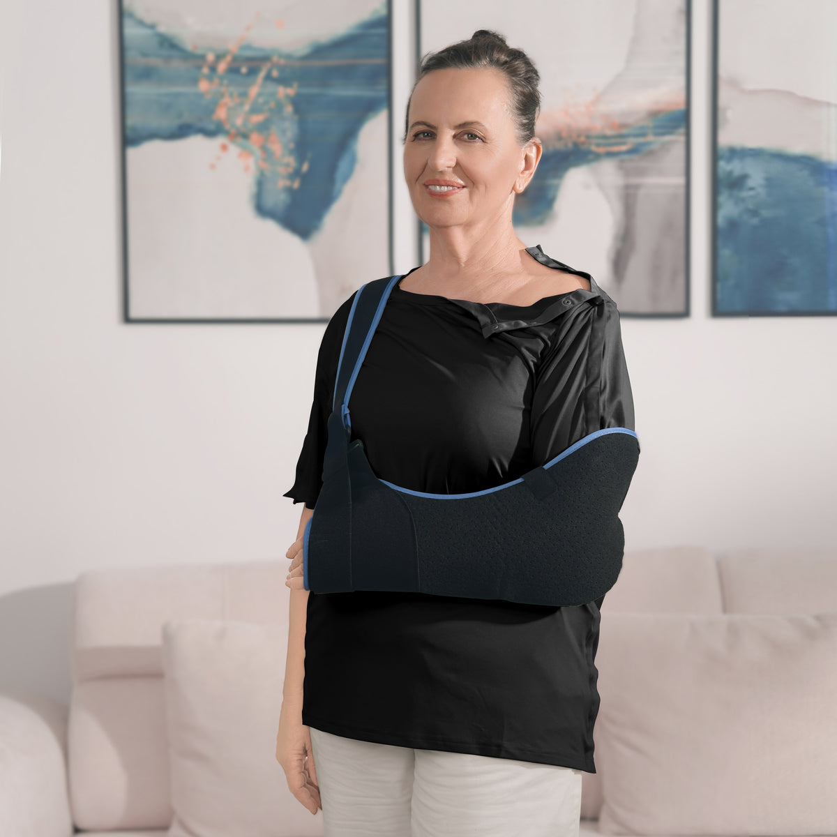 Woman wearing a Black side-snap shirt with shoulder snaps open and an arm sling.