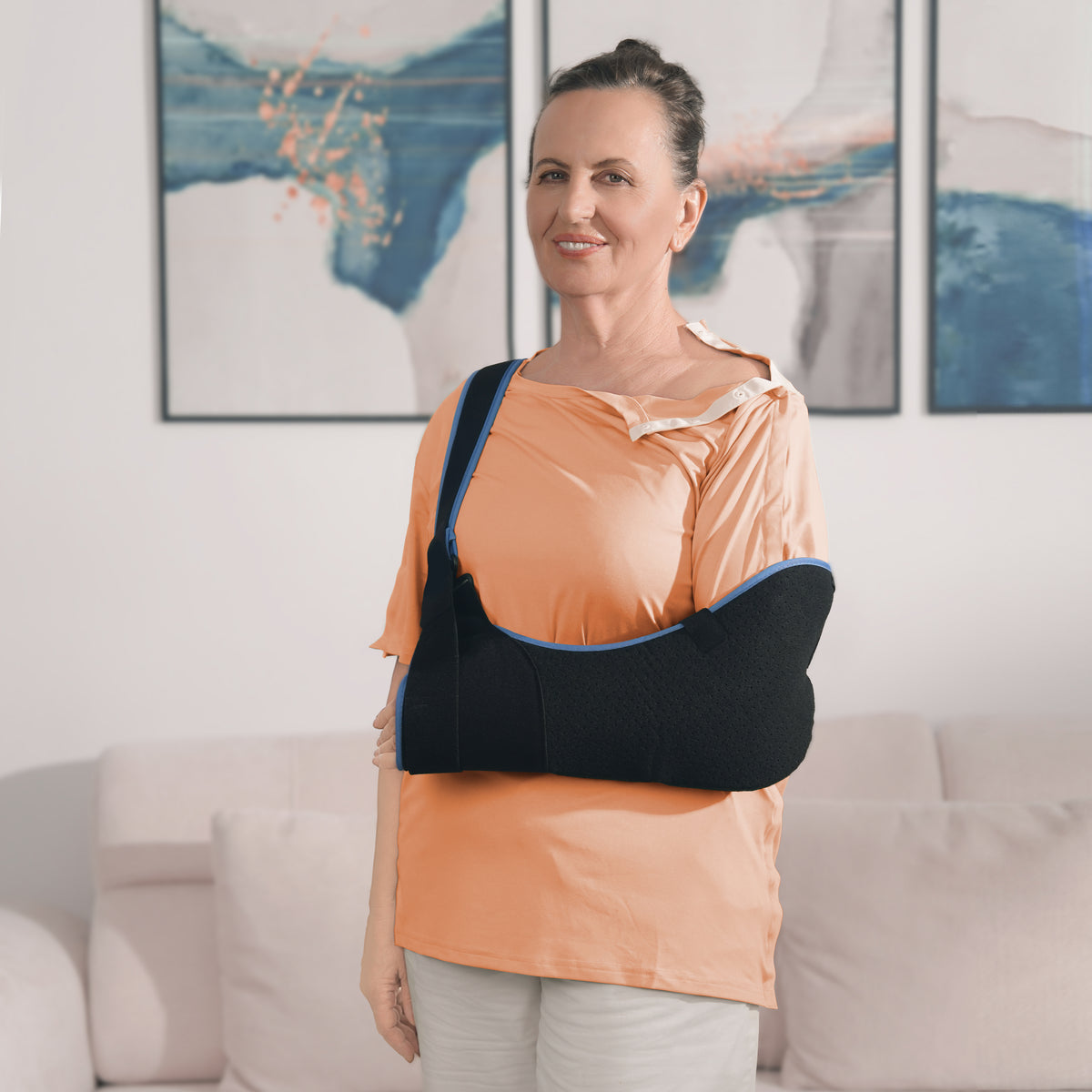 Woman wearing a Burnt Orange side-snap shirt with shoulder snaps open and an arm sling.