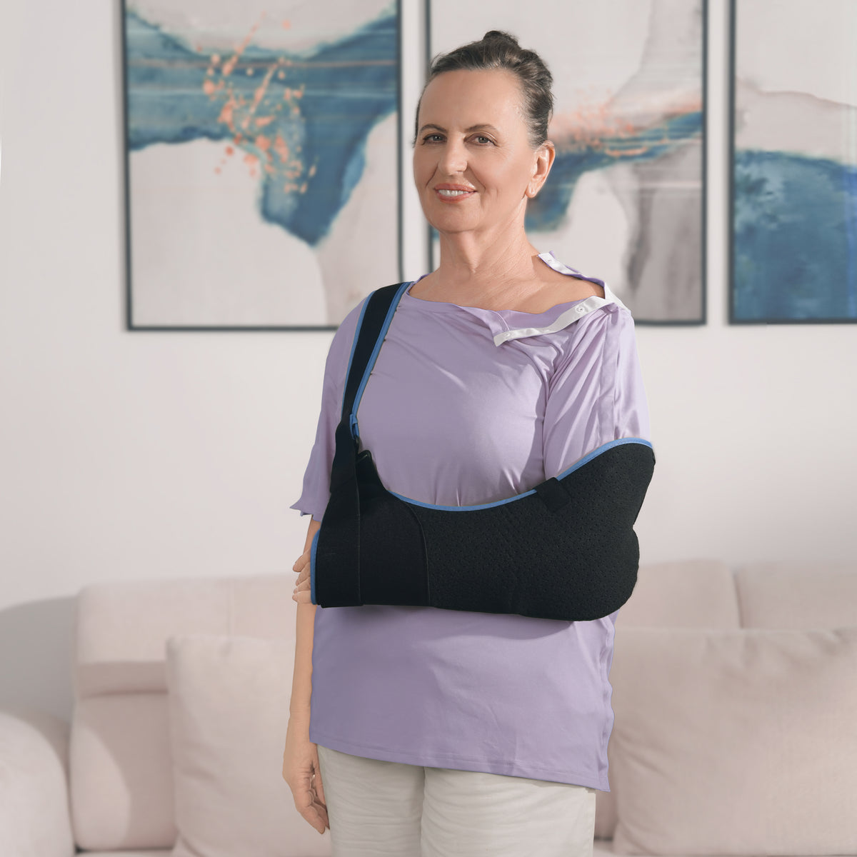 Woman wearing a Lavender Mist side-snap shirt with shoulder snaps open and an arm sling.
