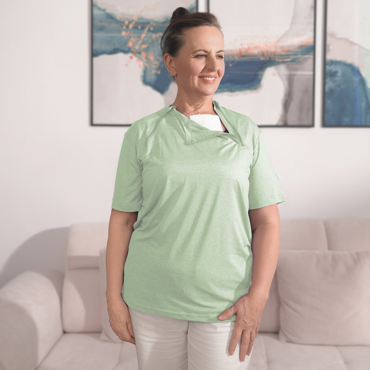 Woman wearing a Sage Green port-access shirt with the chest panel partly open.