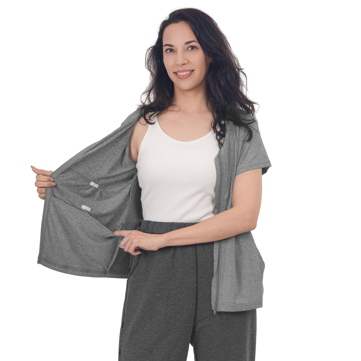 Woman holding a Fog Gray front-zip shirt open to show the inner pockets.