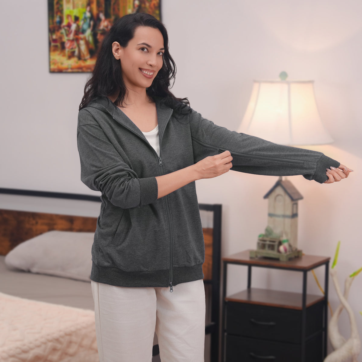 Woman showing the sleeve zipper on a Gray zip hoodie.